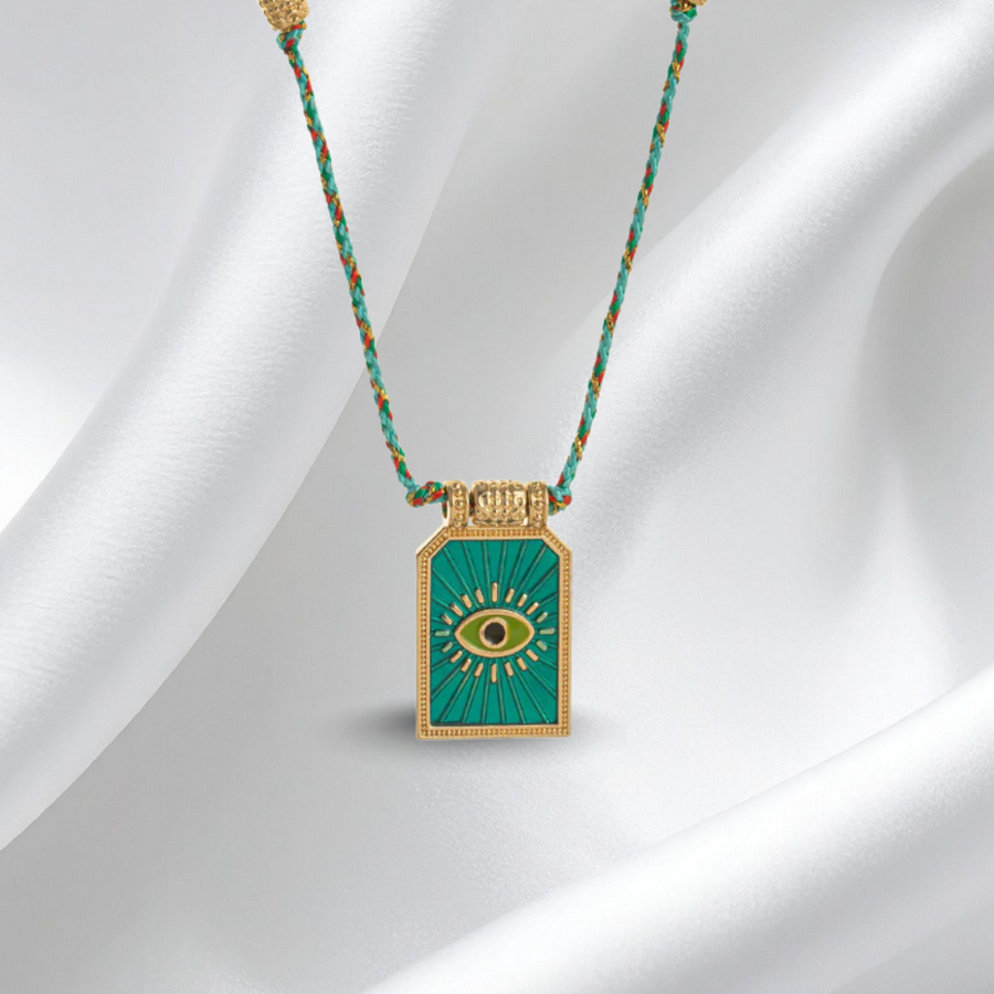 Necklace with a green pendant on a white fabric background