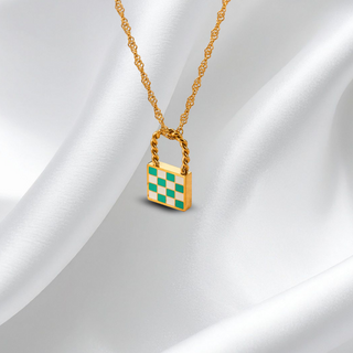Gold necklace with a checkered lock pendant on a white fabric background