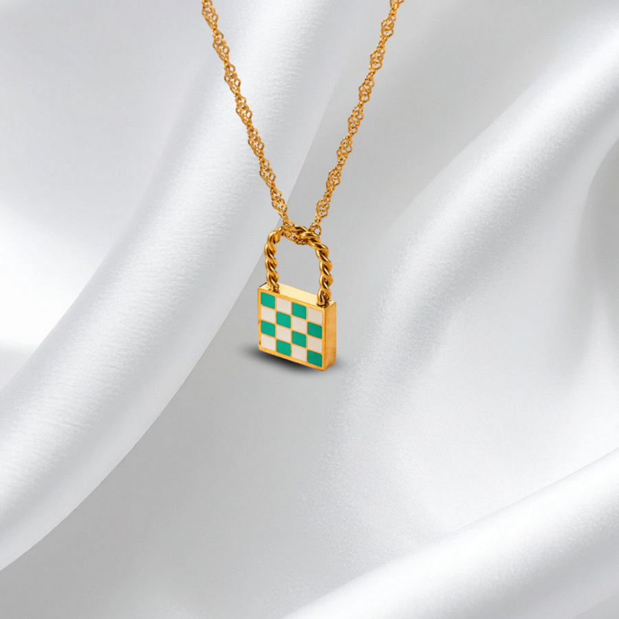 Gold necklace with a checkered lock pendant on a white fabric background