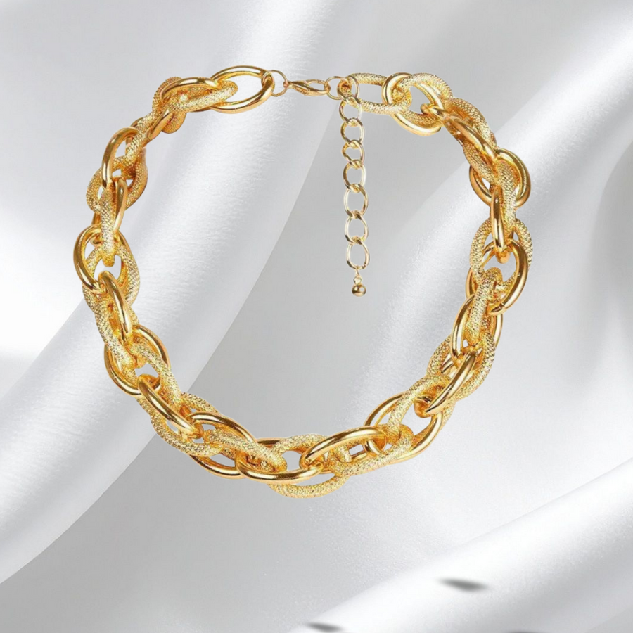 Gold chain necklace on a white satin background