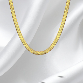 Gold chain necklace on a white fabric background