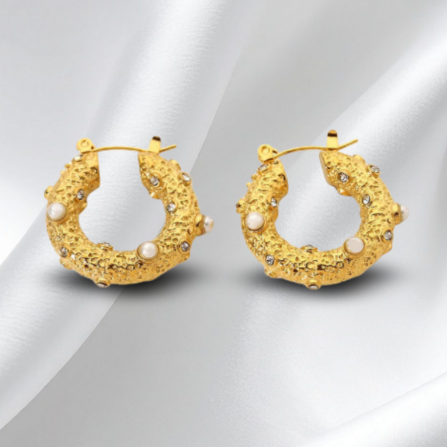 Gold hoop earrings with pearl accents on a white background