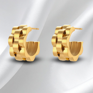 Gold hoop earrings on a light gray background