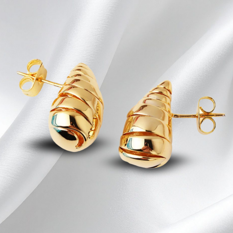 Pair of gold earrings on a white fabric background