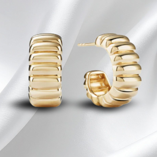 Gold hoop earrings on a light gray background