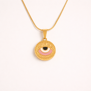 Gold necklace with a round pendant featuring an eye design on a white background