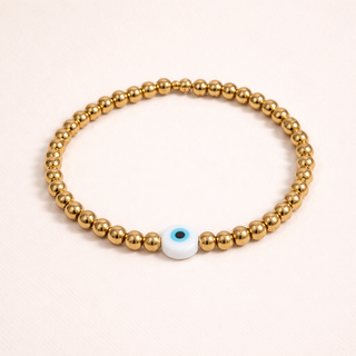 Delicate gold bead bracelet featuring a symbolic evil eye charm for protection and effortless everyday elegance.