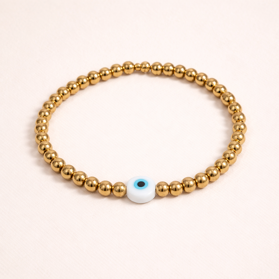 Delicate gold bead bracelet featuring a symbolic evil eye charm for protection and effortless everyday elegance.
