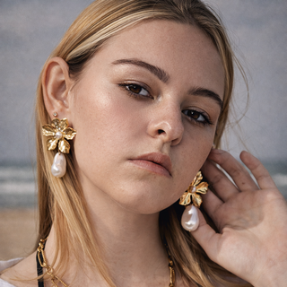 Woman wearing gold earrings with Pearline Trio
