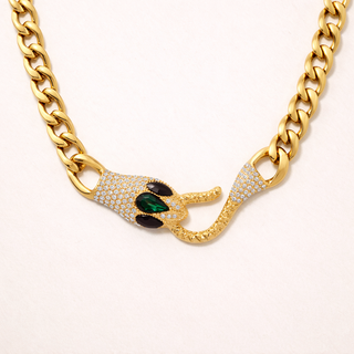 Gold chain necklace with a snake-shaped clasp featuring green stones 
