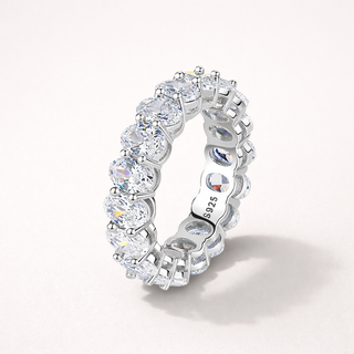 Silver ring with clear gemstones on a white background