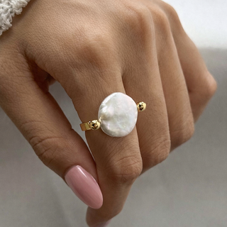 Oceana Pearl Ring Hand wearing a ring with a large white stone and gold band