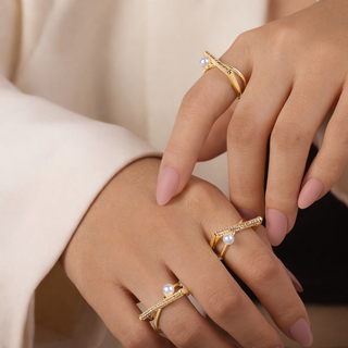Pearl Bar hands wearing gold rings 