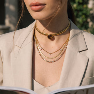 Amber Resin Choker worn with layered necklaces, styled with a beige jacket