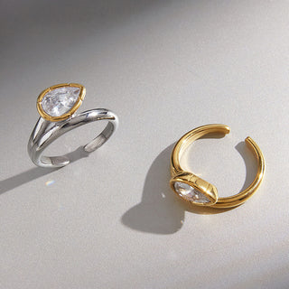 Bezel Elongated Ring in silver and gold tones displayed together on a grey background