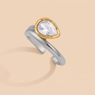 Bezel Elongated Ring close-up showing the bezel-set pear-cut zircon on a beige background
