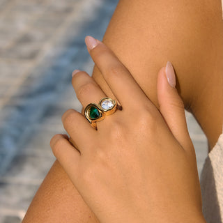 Bezel Emerald Ring worn on a hand outdoors, close-up on the emerald and clear zircon stones