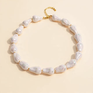 Pearl necklace with gold clasp on a beige background