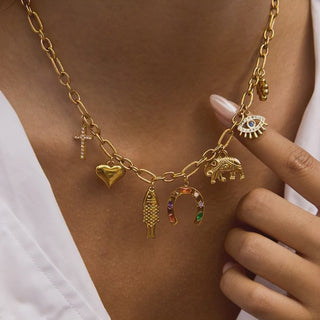 Gold necklace with various charms on a person's neck
