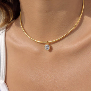 Gold necklace with a diamond pendant on a person's neck