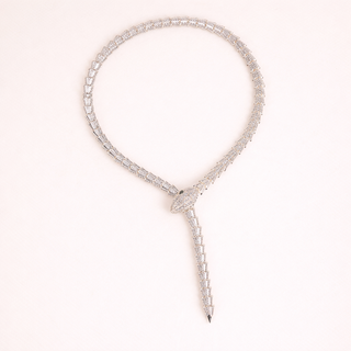 Silver necklace with a pendant on a light pink background