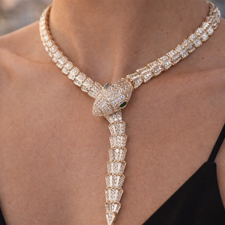 Luxury diamond necklace with snake design on a person wearing a black top.