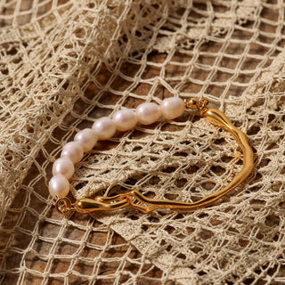 Pearl bracelet with gold clasp on a textured beige fabric background