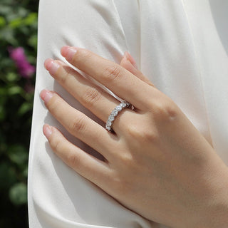 Hand wearing a moissanite ring on a blurred natural background