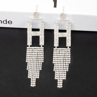 Silver beaded earrings on a black background