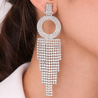 Earring with circular design and dangling crystals on a blurred background