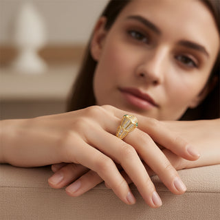 Woman wearing a smoddo  gold adjustable snake ring with a green gemstone on a blurred background