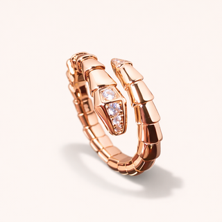 Rose gold serpentine ring with diamond on a white background