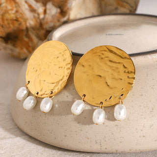 smoddo solenne earrings Gold earrings with pearl drops on a textured surface