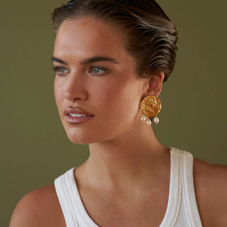 Woman wearing smoddo solenne  gold earrings with a green background