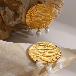 smoddo solenne earrings Gold earrings with pearl drops on a stone background